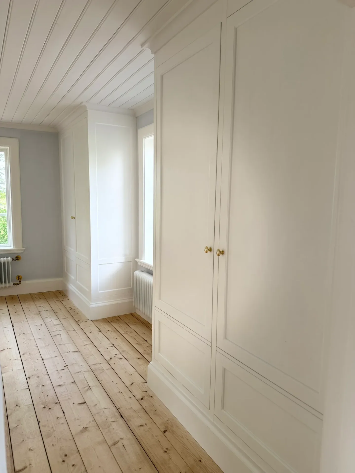 Platsbyggd vit skåpvägg med spegeldörrar