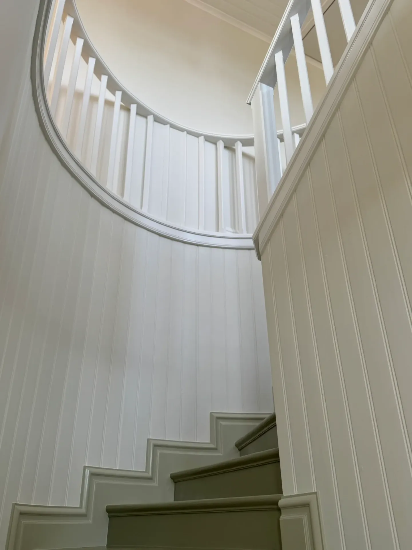 Rund trapphall med vit pärlspont och balustrad