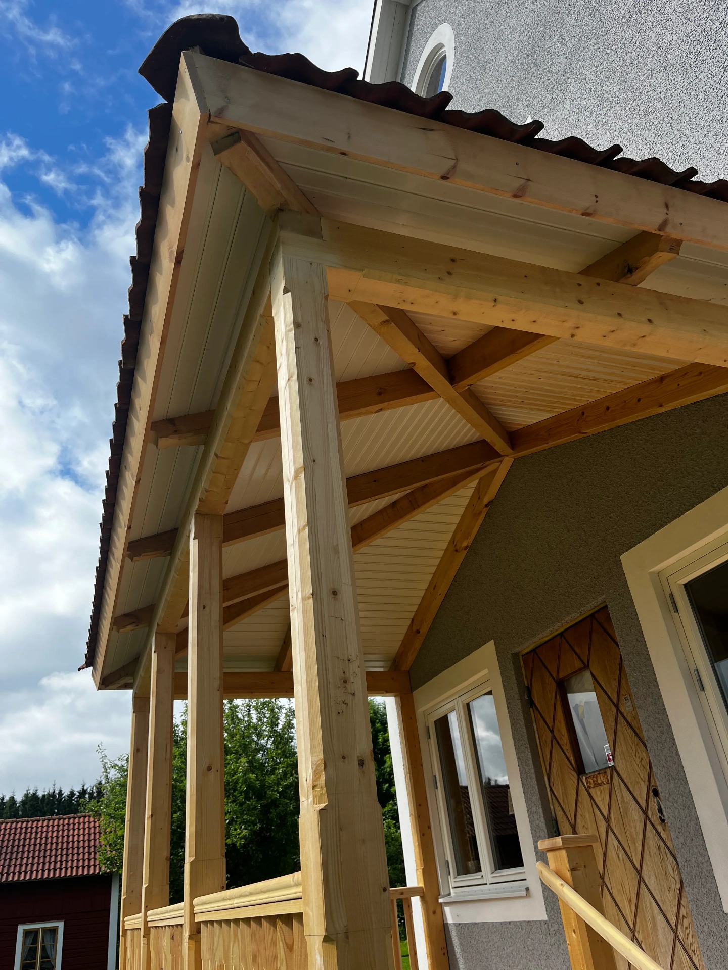 Förstukvist i trä med sadeltak och snidade detaljer